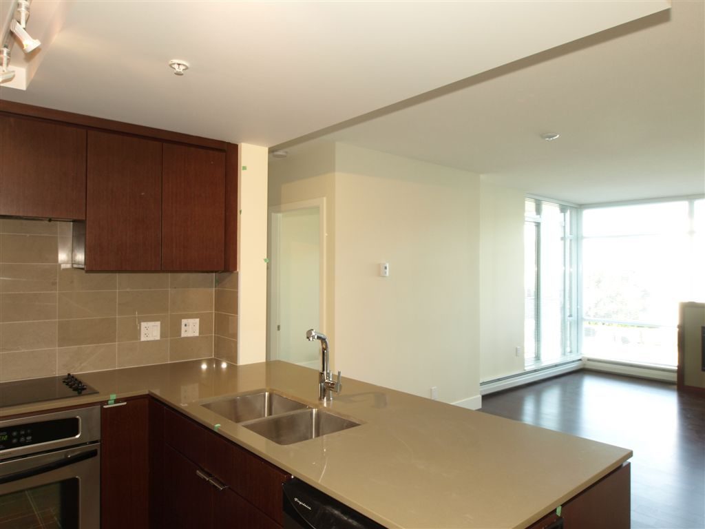 Bright kitchen with modern counter, dark wood cabinets, and city view. - 104 - 1320 Chesterfield, North Vancouver