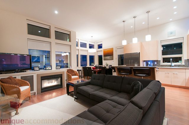 Open-plan living and dining area with modern furnishings, hardwood floors, and a city view. - 1381 Bute Street, Vancouver Downtown
