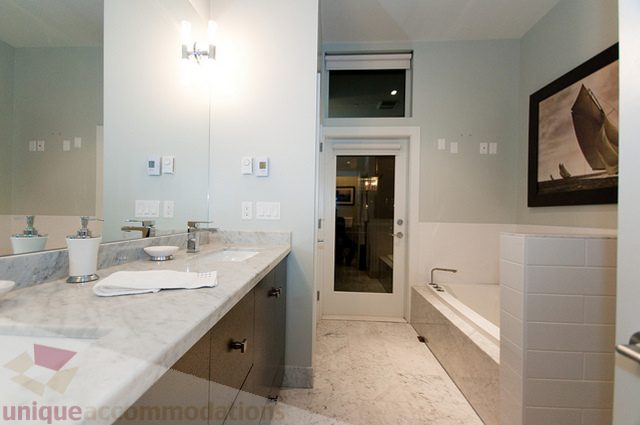 Furnished bathroom with marble countertops and a large mirror. - 1381 Bute Street, Vancouver Downtown