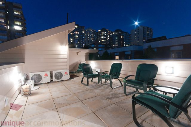 Furnished rooftop patio with city view and ambient lighting. - 1381 Bute Street, Vancouver Downtown