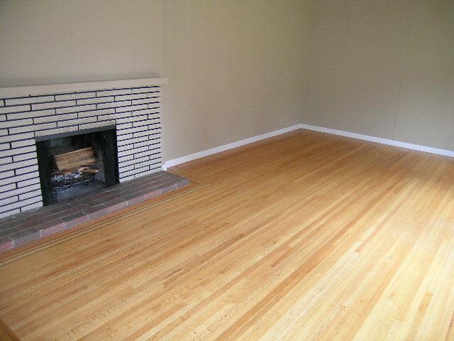 Spacious living room with hardwood floors and a brick fireplace. - 43 Glenmore Drive, West Vancouver