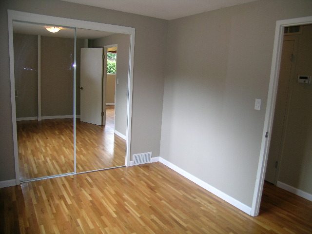 Spacious living room with hardwood floors and large sliding glass doors leading to a balcony. - 43 Glenmore Drive, West Vancouver