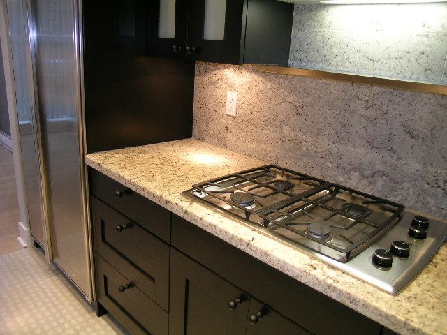 Modern kitchen with granite countertops and stainless steel appliances, perfect for a cozy downtown townhouse.