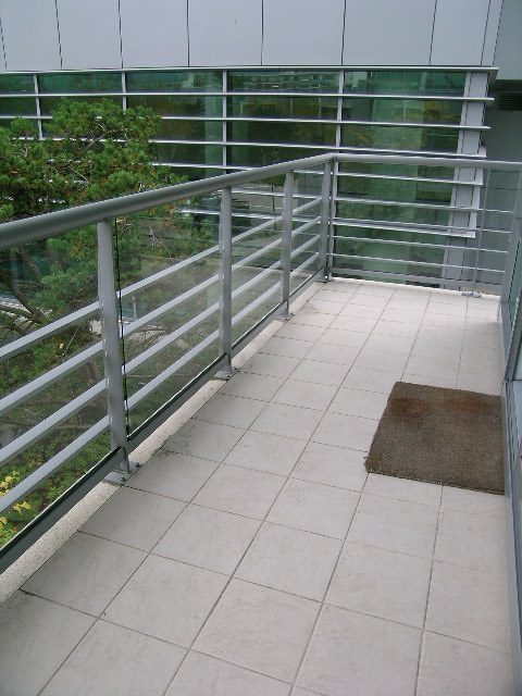 Spacious balcony with modern railings and tiled flooring, perfect for enjoying city views. - 1455 West Hastings, Vancouver Downtown