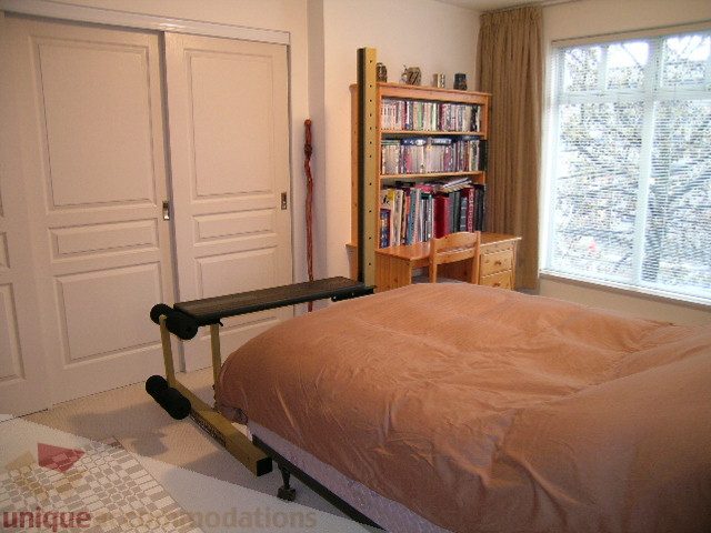 Spacious bedroom with twin beds, built-in storage, and a large window offering a view. - 215 - 3727 West 10th Avenue, Vancouver West Side