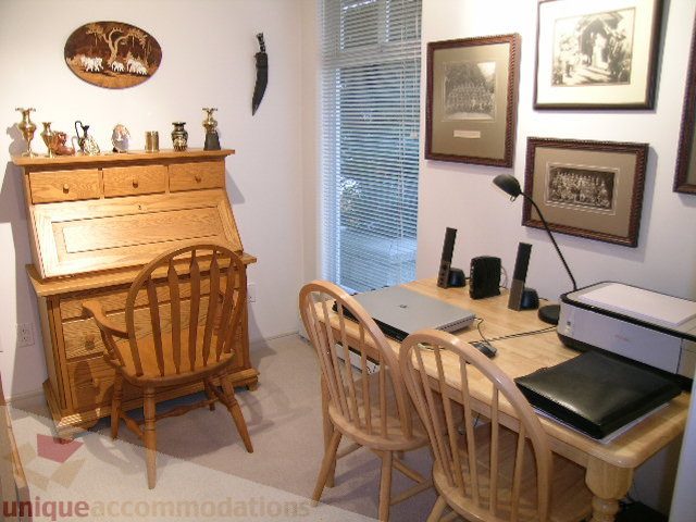 Cozy den with wooden furniture, a desk, and framed artwork, perfect for a home office. - 215 - 3727 West 10th Avenue, Vancouver West Side