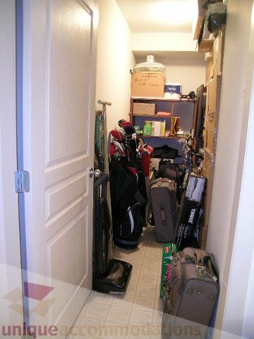 Narrow hallway with storage shelves and luggage, leading to a cozy 2-bedroom + den condo. - 215 - 3727 West 10th Avenue, Vancouver West Side