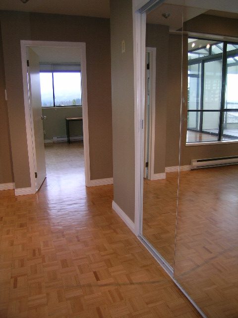 Spacious living room with hardwood floors and a large window offering a city view. - 801- 505 Lonsdale Avenue, North Vancouver