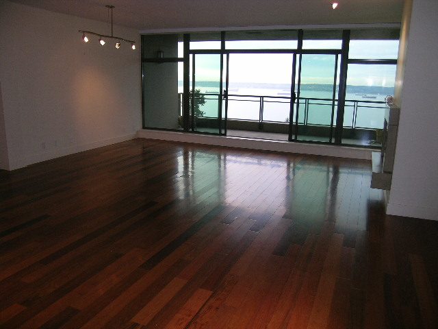 Bright living room with hardwood floors and a large window offering a city view. - 602 - 3355 Cypress Place, West Vancouver