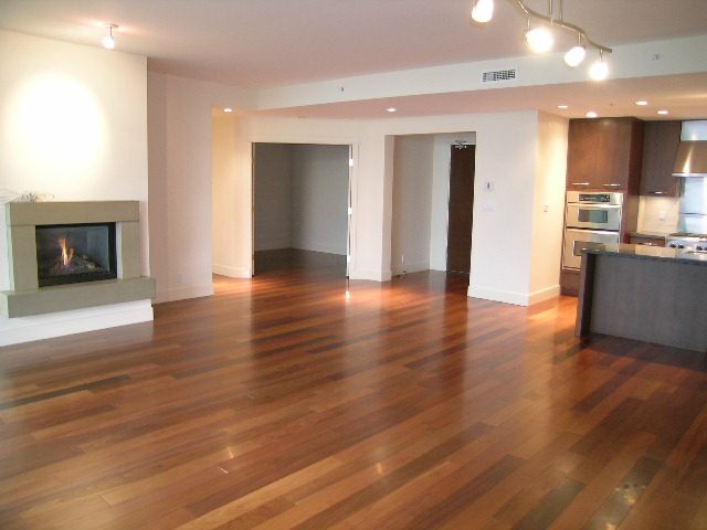 Open-concept living space with hardwood floors and a modern fireplace. - 602 - 3355 Cypress Place, West Vancouver