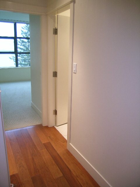 Bright hallway with hardwood floors and a view of the city through the window. - 602 - 3355 Cypress Place, West Vancouver