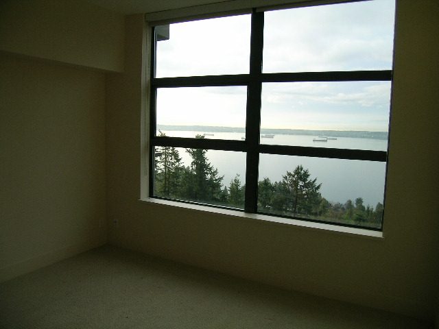 Bright living room with large window offering a stunning city view. - 602 - 3355 Cypress Place, West Vancouver