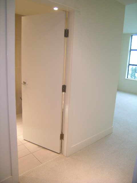 Bright hallway leading to a den with white walls and tiled flooring. - 602 - 3355 Cypress Place, West Vancouver