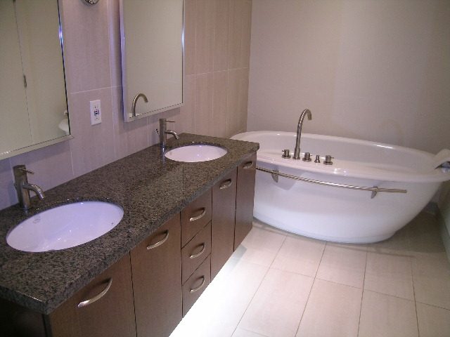 Furnished bathroom with granite countertops and a modern bathtub. - 602 - 3355 Cypress Place, West Vancouver