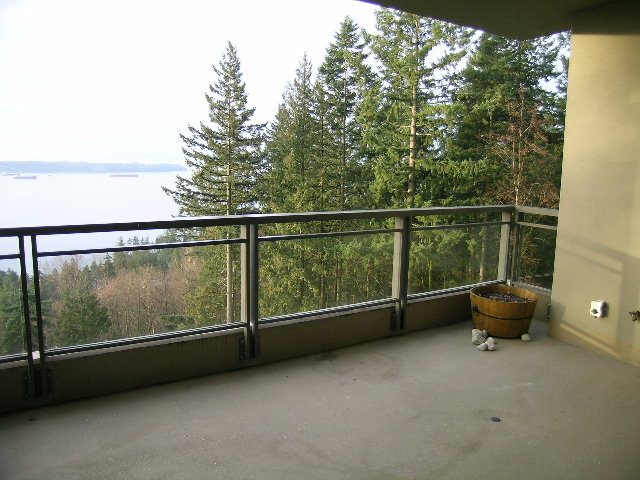 Balcony with city view and lush greenery, featuring a wooden planter and metal railings. - 602 - 3355 Cypress Place, West Vancouver
