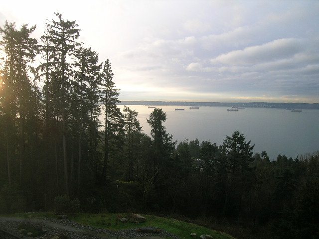 Bright living room with city view and lush forest backdrop. - 602 - 3355 Cypress Place, West Vancouver