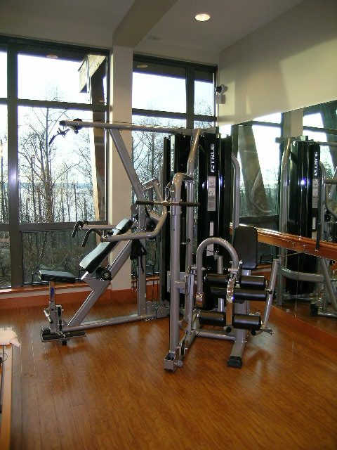 Bright gym with large windows, hardwood floors, and exercise equipment. - 602 - 3355 Cypress Place, West Vancouver