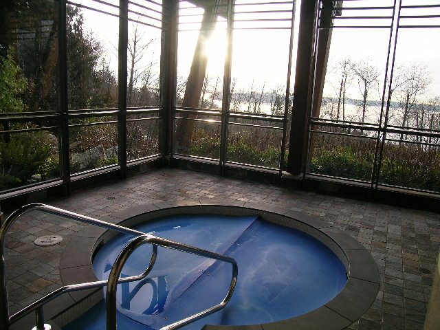 Bright sunlit hot tub with a stunning view of the water and trees. - 602 - 3355 Cypress Place, West Vancouver