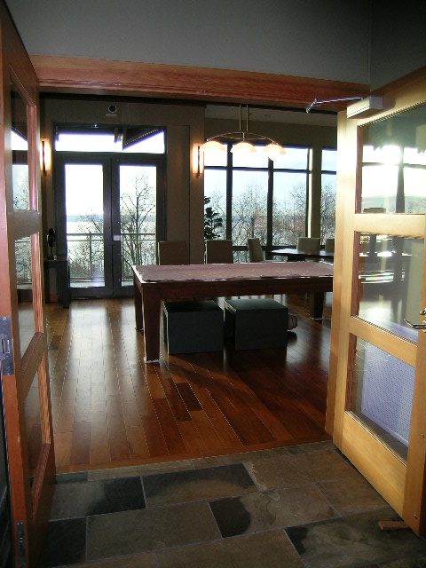 Furnished dining area with hardwood floors and large windows offering a city view. - 602 - 3355 Cypress Place, West Vancouver