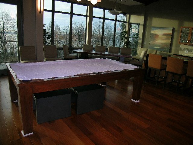 Furnished living room with hardwood floors, large windows, and a pool table. - 602 - 3355 Cypress Place, West Vancouver