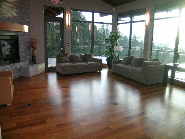 Furnished living room with hardwood floors, large windows, and a cozy fireplace. - 602 - 3355 Cypress Place, West Vancouver
