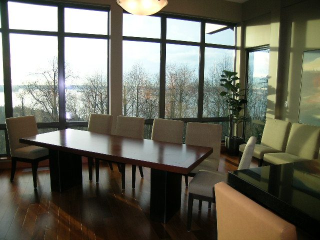 Furnished dining area with large windows, hardwood floors, and a city view. - 602 - 3355 Cypress Place, West Vancouver