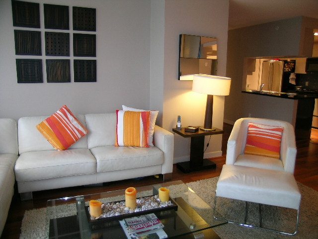 Living room with modern furniture, hardwood floors, and a glass coffee table. - 508 - 1408 Strathmore Mews, Vancouver Downtown