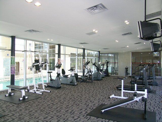 Bright and spacious gym with cardio machines and free weights, large windows offering city views. - 508 - 1408 Strathmore Mews, Vancouver Downtown