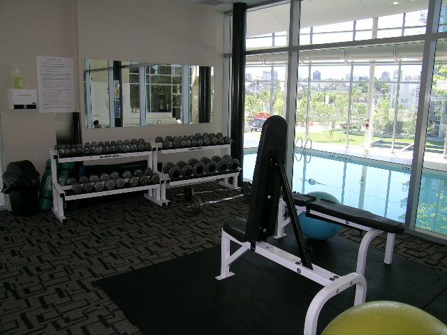 Fitness room with dumbbells and weight bench, city view outside. - 508 - 1408 Strathmore Mews, Vancouver Downtown