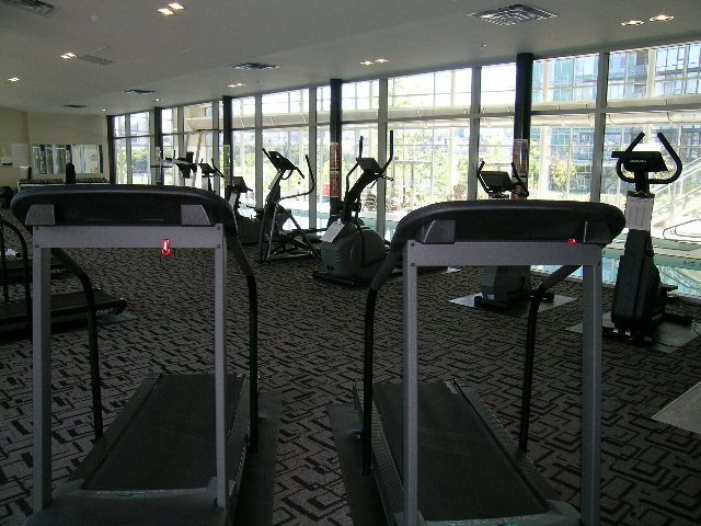 Fitness room with treadmills and large windows overlooking the city. - 508 - 1408 Strathmore Mews, Vancouver Downtown
