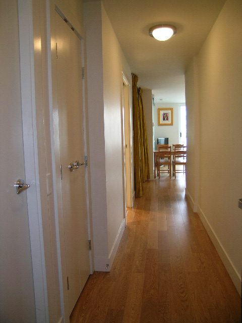 Narrow hallway with hardwood floors and a door leading to a cozy den area. - 608 - 565 Smithe Street, Vancouver Downtown