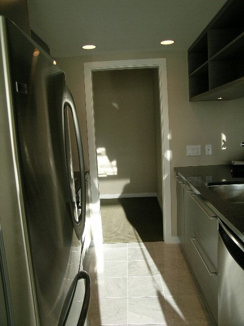 Bright kitchen with stainless steel appliances, light-colored countertops, and a tiled floor. - 2307 - 833 Seymour Street, Vancouver Downtown