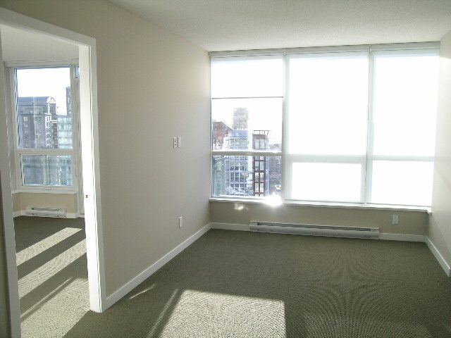 Bright living room with large windows and city view, carpeted floor, and modern furnishings. - 2307 - 833 Seymour Street, Vancouver Downtown