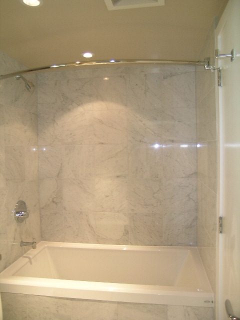 Spacious bathroom with marble tiles and a modern bathtub. - 2307 - 833 Seymour Street, Vancouver Downtown
