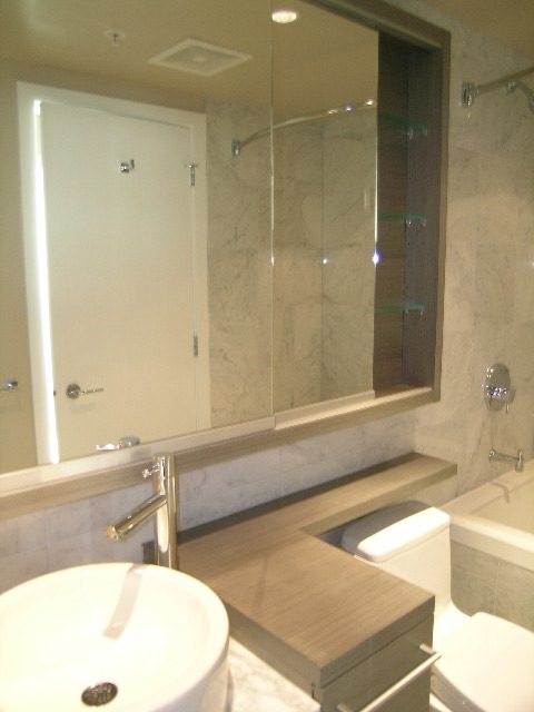 Modern bathroom with sleek marble countertops and a glass-enclosed shower. - 2307 - 833 Seymour Street, Vancouver Downtown