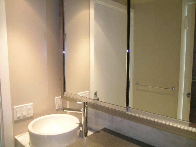 Modern bathroom with sleek countertop and large mirror, offering a clean and contemporary feel. - 2307 - 833 Seymour Street, Vancouver Downtown