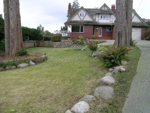 Spacious living room with cozy fireplace and large windows. - 1875 26th Street, West Vancouver