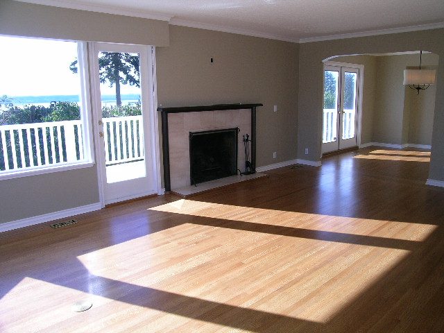 Spacious living room with hardwood floors, fireplace, and sliding doors leading to a balcony. - 1875 26th Street, West Vancouver