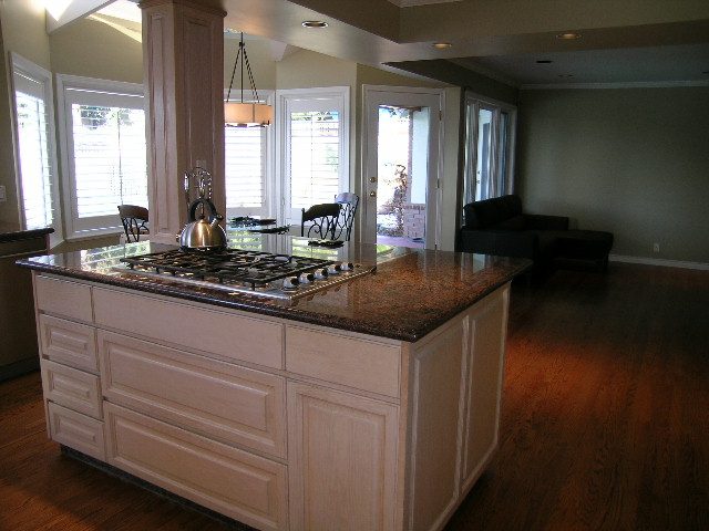 Bright kitchen with granite countertops, hardwood floors, and a view of the living room. - 1875 26th Street, West Vancouver
