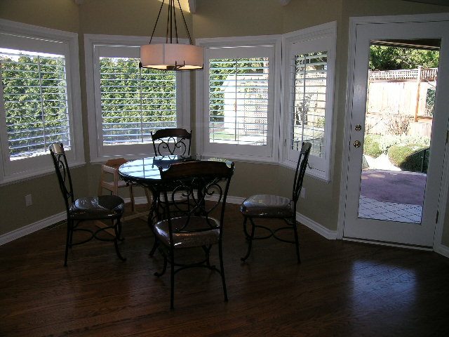 Bright dining area with hardwood floors, large windows, and a view of the backyard. - 1875 26th Street, West Vancouver