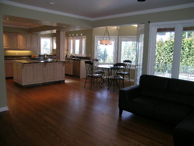 Open-concept living with hardwood floors, kitchen island, and large windows offering a view. - 1875 26th Street, West Vancouver