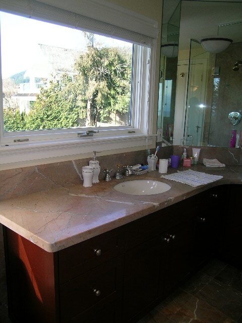 Bathroom with marble countertops, dark cabinets, and a view of trees outside. - 1875 26th Street, West Vancouver