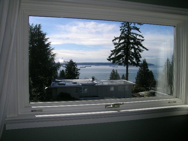 Spacious living room with a stunning view of the ocean and surrounding trees. - 1875 26th Street, West Vancouver