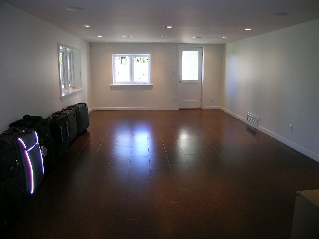 Spacious living room with hardwood floors and large windows, perfect for a cozy stay. - 1875 26th Street, West Vancouver