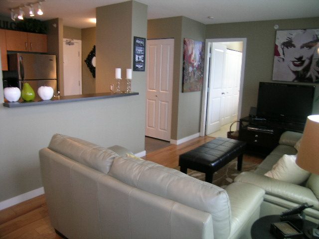 Spacious living room with white leather couches, hardwood floors, and modern decor. - 2109 - 1295 Richards Street, Vancouver Downtown