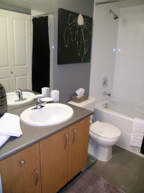 Modern bathroom with wooden cabinets, granite countertops, and a sleek shower setup. - 2109 - 1295 Richards Street, Vancouver Downtown