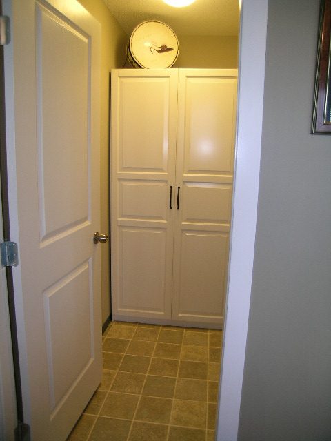Spacious laundry room with white cabinets and beige tile flooring. - 2109 - 1295 Richards Street, Vancouver Downtown