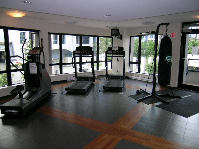 Spacious fitness room with cardio equipment, large windows, and hardwood floors. - 2109 - 1295 Richards Street, Vancouver Downtown