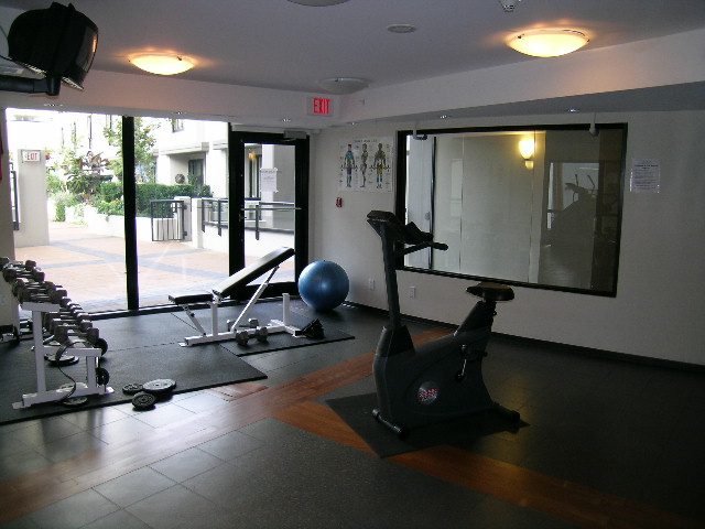 Spacious fitness studio with mirrored walls, cardio equipment, and natural light. - 2109 - 1295 Richards Street, Vancouver Downtown