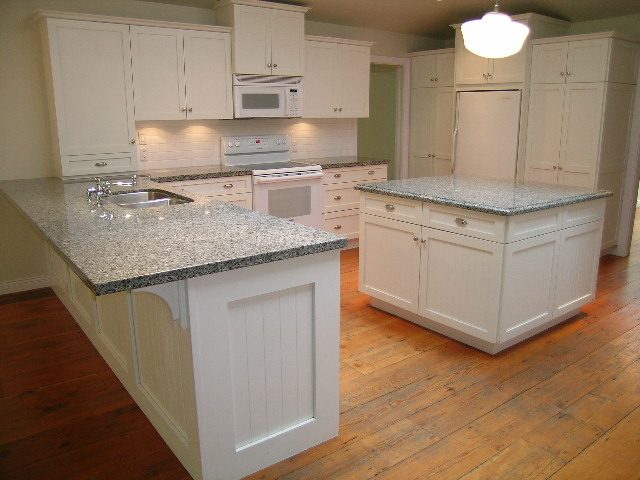 Bright kitchen with white cabinets, granite countertops, and hardwood floors. - 2795 Palmerston Avenue, West Vancouver